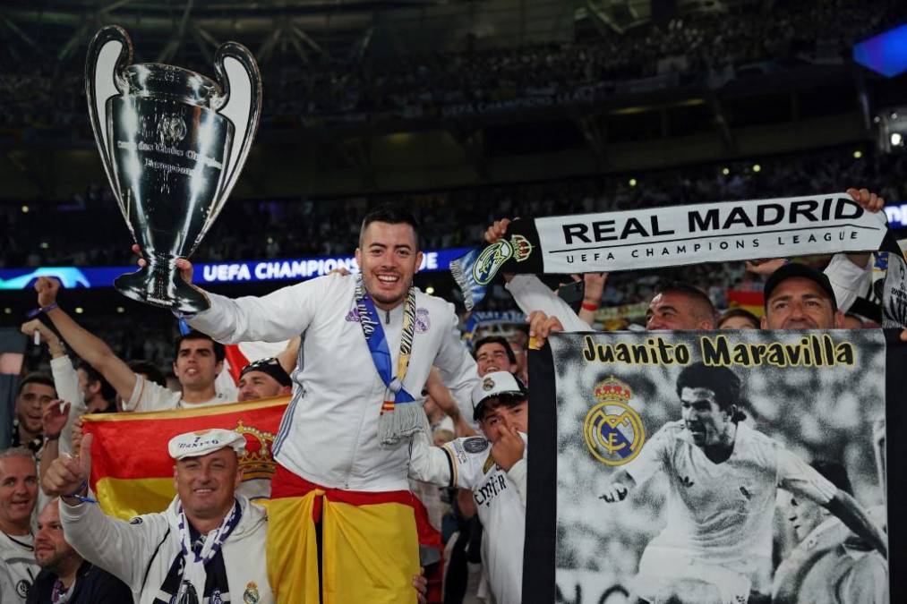 <i>Los seguidores del Real Madrid celebran con un trofeo simulado después de que su equipo ganó el partido de fútbol final de la Liga de Campeones de la UEFA entre el Borussia Dortmund y el Real Madrid, en el estadio de Wembley, en Londres, el 1 de junio de 2024. El Real Madrid gana la final de la Liga de Campeones 2 - 0 contra Borussia Dortmund. (Foto de Adrián DENNIS / AFP)</i>