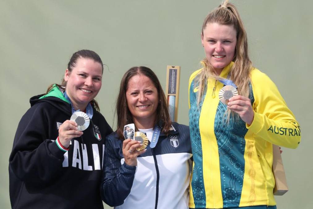 <i>(De izq. a der.) La medallista de plata de Italia Silvana Maria Stanco, la medallista de oro de Guatemala Adriana Ruano Oliva y la medallista de bronce de Australia Penny Smith posan en el podio de la final femenina de tiro al plato durante los Juegos Olímpicos de París 2024 en el Centro de Tiro de Chateauroux el 31 de julio de 2024. (Foto de Alain JOCARD / AFP)</i>