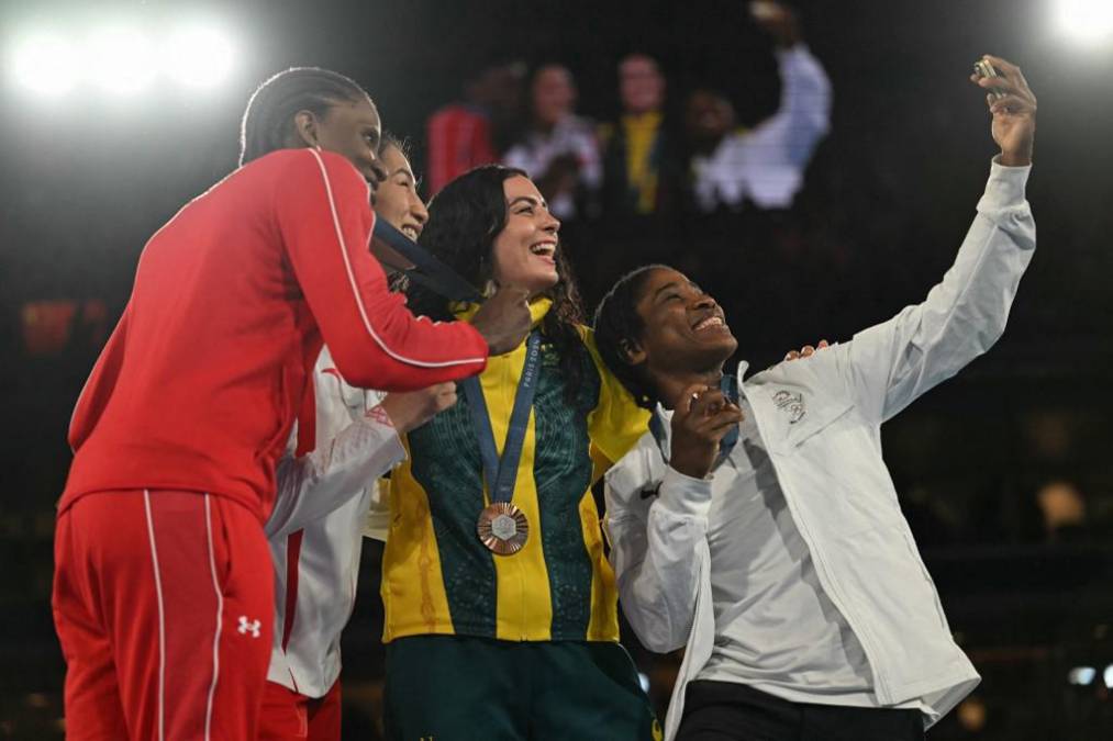 <i>(De izq. a der.) La medallista de plata Atheyna Bibeichi Bylon de Panamá, la medallista de oro Li Qian de China y las medallistas de bronce Caitlin Parker de Australia y Cindy Winner Djankeu Ngamba del Equipo Olímpico de Refugiados posan para una selfie en el podio durante la ceremonia de entrega de medallas de la categoría final de boxeo femenino de 75 kg durante los Juegos Olímpicos de París 2024 en el Estadio Roland-Garros, en París el 10 de agosto de 2024. (Foto de Mauro PIMENTEL / AFP)</i>