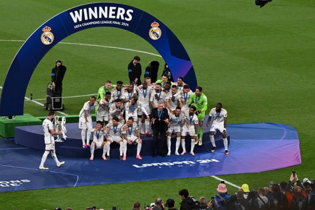 <i>El defensor español del Real Madrid #06 Nacho Fernández (L) trae el trofeo para celebrar con sus compañeros de equipo después del partido final de la Liga de Campeones de la UEFA entre el Borussia Dortmund y el Real Madrid, en el estadio de Wembley, en Londres, el 1 de junio de 2024. (Foto de JUSTIN TALLIS/AFP)</i>