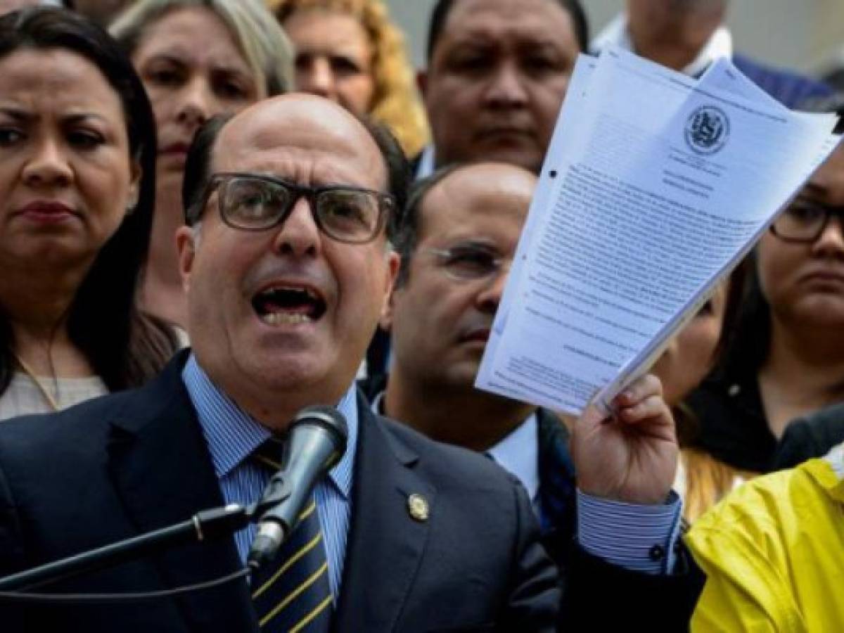 The president of Venezuela's National Assembly Julio Borges, holds a copy of a sentence from Venezuela's Supreme Court granting itself legislative powers, as he speaks during a press conference in Caracas on March 30, 2017.Venezuela's Supreme Court took over legislative powers Thursday from the opposition-majority National Assembly, whose speaker accused leftist President Nicolas Maduro of staging a 'coup.' / AFP PHOTO / FEDERICO PARRA