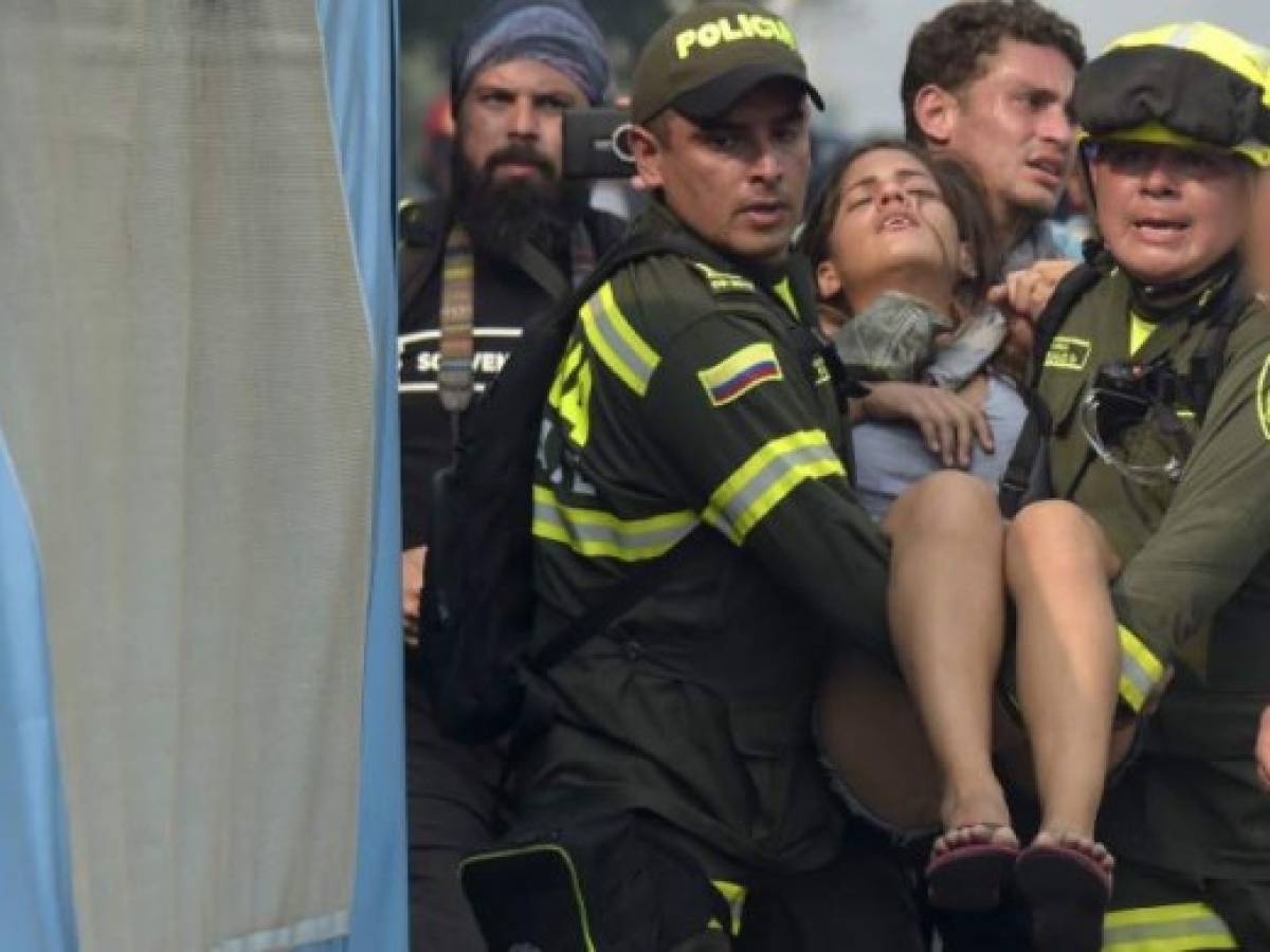 The police carry an injured woman during clashes at the Francisco de Paula Santander international bridge Bridge linking Cucuta, Colombia, and Urena, Venezuela, during an attempt to cross humanitarian aid over the border into Venezuela, on February 23, 2019. - US-donated humanitarian aid was 'on its way' to Venezuela, opposition leader Juan Gauido announced Saturday as he launched a distribution operation with the presidents of Colombia, Chile and Paraguay. (Photo by RAUL ARBOLEDA / AFP)