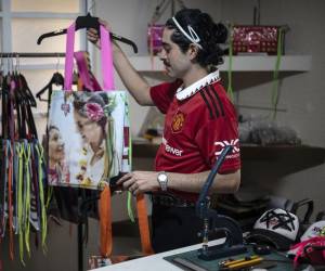 El diseñador de moda mexicano Mizael Perea, de 33 años, muestra uno de los diseños de bolsos hechos con materiales de carteles de campaña electoral en su taller en la Ciudad de México el 27 de junio de 2024.FOTO Yuri CORTEZ/AFP