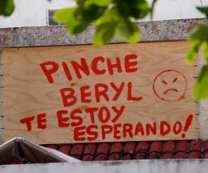 <i>Un cartel que dice 'Pinche Beryl, te estoy esperando' en referencia a la posible llegada del huracán Beryl se ve afuera de una casa residencial en Cancún, estado de Quintana Roo, México, el 3 de julio de 2024. FOTO Isabel Ruiz/AFP</i>