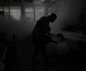 <i>Un trabajador rocía insecticidas contra el mosquito Aedes aegypti dentro de una escuela. FOTO JUAN ORDÓNEZ / AFP</i>