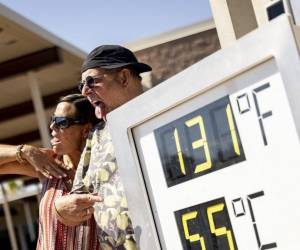 <i>Los visitantes posan junto a un termómetro que marca 131 grados Fahrenheit y 55 grados Celsius en el Centro de Visitantes del Parque Nacional del Valle de la Muerte, cerca de Furnace Creek, durante una ola de calor que afectó al sur de California el 7 de julio de 2024. FOTO ÉTIENNE LAURENT / AFP</i>