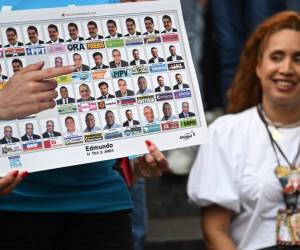 <i>Un partidario del candidato presidencial venezolano Edmundo González Urrutia y la líder de la oposición María Corina Machado muestra una imagen de la papeleta durante una manifestación con fieles cristianos en Caracas el 21 de julio de 2024. Venezuela celebrará sus elecciones presidenciales el 28 de julio. FOTO Raúl ARBOLEDA / AFP</i>