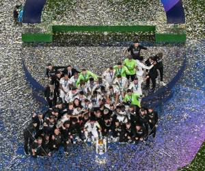 Los jugadores del Real Madrid celebran su victoria con el trofeo en el podio tras disputar la final de la Liga de Campeones de la UEFA contra el Borussia Dortmund, en el estadio de Wembley, en Londres, el 1 de junio de 2024. (Foto de Ben Stansall / AFP )