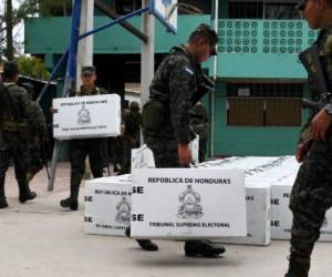 Honduran army soldiers carry election material to polling stations in Tegucigalpa on November 25, 2017, the day before the general elections. President Juan Orlando Hernandez is poll favorite for Sunday's elections, and expects to be re-elected despite the one-term limit set by the constitution. His conservative National Party contends that a 2015 Supreme Court ruling voided that restriction. But the opposition argues that the court does not have the power to overrule the constitution. / AFP PHOTO / Orlando SIERRA