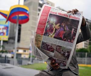 <i>Un hombre lee un periódico en Caracas el 29 de julio de 2024, un día después de las elecciones presidenciales venezolanas. El presidente Nicolás Maduro fue declarado ganador de las elecciones presidenciales de Venezuela, pero la oposición y los principales vecinos regionales rechazaron de inmediato los resultados oficiales. FOTO Raúl ARBOLEDA / AFP</i>