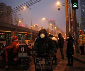 <i>En la imagen de archivo, peatones utilizan mascarillas para protegerse de la contaminación en Pekín (China). EFE/How Hwee Young</i>