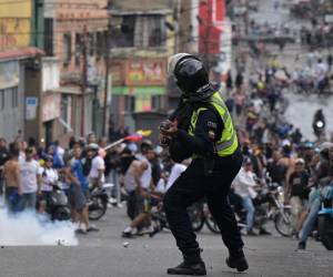 <i>Un policía antidisturbios lanza gases lacrimógenos contra manifestantes durante una protesta de opositores al gobierno del presidente venezolano Nicolás Maduro en el barrio de Catia, en Caracas, el 29 de julio de 2024, un día después de las elecciones presidenciales venezolanas. Las protestas estallaron el lunes en algunas partes de Caracas contra la reelección reivindicada por el presidente venezolano Nicolás Maduro, pero cuestionada por la oposición y cuestionada a nivel internacional, observaron periodistas de la AFP. FOTO Yuri CORTEZ / AFP</i>