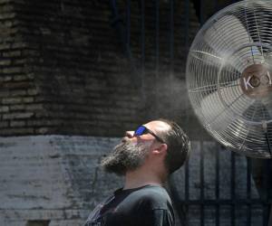 <i>Un ventilador rocía agua a lo largo de las puertas del Coliseo para refrescar a los turistas el 11 de julio de 2024 en Roma, donde las temperaturas alcanzan los 38 grados centígrados. FOTO Tiziana FABI/AFP</i>