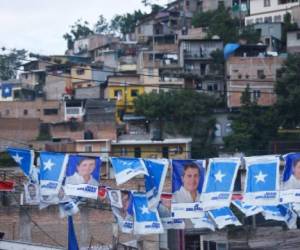 Rótulos de campañas del presidente de Honduras, Juan Orlando Hernandez, se observan en un barrio de Tegucigalpa, el 23 de noviembre de 2017. AFP PHOTO / RODRIGO ARANGUA