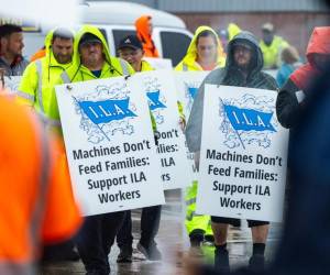 Miembros del sindicato de la Asociación Internacional de Estibadores (ILA) hacen piquete bajo la lluvia en la primera mañana de su huelga por un nuevo contrato laboral frente a la Terminal Marítima de Dundalk en Baltimore, Maryland, EE.UU. EFE/EPA/Jim Lo Scalzo