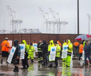 Miembros del sindicato de la Asociación Internacional de Estibadores (ILA) hacen piquetes bajo la lluvia en la primera mañana de su huelga por un nuevo contrato laboral frente a la Terminal Marítima de Dundalk en Baltimore, Maryland, EE.UU. EFE/EPA/Jim Lo Scalzo