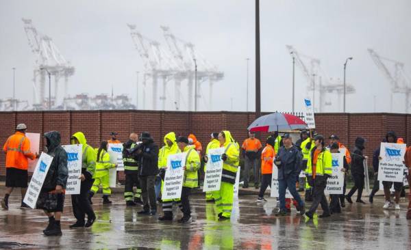 Miembros del sindicato de la Asociación Internacional de Estibadores (ILA) hacen piquetes bajo la lluvia en la primera mañana de su huelga por un nuevo contrato laboral frente a la Terminal Marítima de Dundalk en Baltimore, Maryland, EE.UU. EFE/EPA/Jim Lo Scalzo