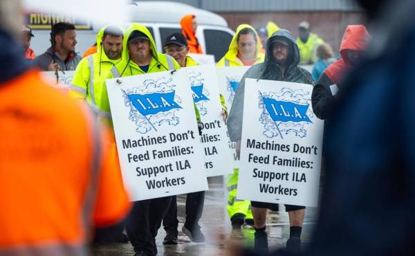 Miembros del sindicato de la Asociación Internacional de Estibadores (ILA) hacen piquete bajo la lluvia en la primera mañana de su huelga por un nuevo contrato laboral frente a la Terminal Marítima de Dundalk en Baltimore, Maryland, EE.UU. EFE/EPA/Jim Lo Scalzo