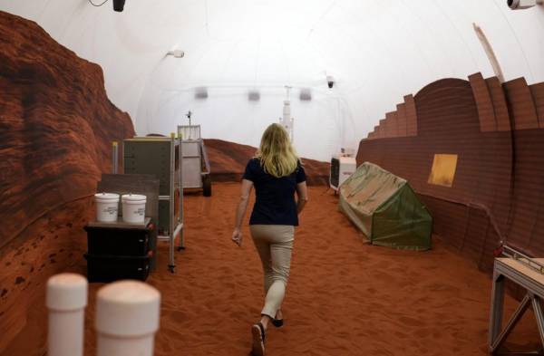 La Dra. Suzanne Bell, líder del Laboratorio de Rendimiento y Salud Conductual de la NASA, camina a través de una porción exterior simulada de Marte del Mars Dune Alpha de CHAPEA en el centro espacial Johnson en Houston, Texas, el 11 de abril de 2023. Mars Dune Alpha de CHAPEA es un dispositivo impreso en 3D. hábitat diseñado para servir como análogo de misiones de un año. FOTO Marcos Félix / AFP