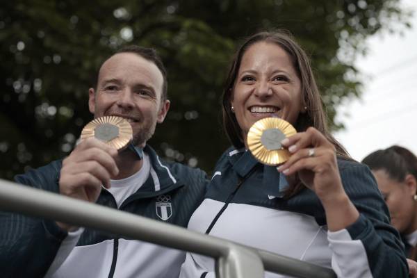 <i>Los tiradores guatemaltecos Adriana Ruano (d) y Jean Pierre Brol, medallistas olímpicos en las pasadas justas de París, fueron registrados este miércoles, 14 de agosto, la exhibir sus preseas, durante una caravana de bienvenida, por las calles de Ciudad de Guatemala (Guatemala). FOTO EFE/David Toro</i>