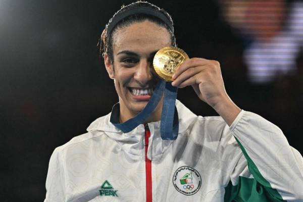 <i>La medallista de oro argelina Imane Khelif posa en el podio durante la ceremonia de entrega de medallas de la categoría final de boxeo femenino de 66 kg durante los Juegos Olímpicos de París 2024 en el Estadio Roland-Garros, en París el 9 de agosto de 2024. FOTO MOHD RASFAN / AFP</i>