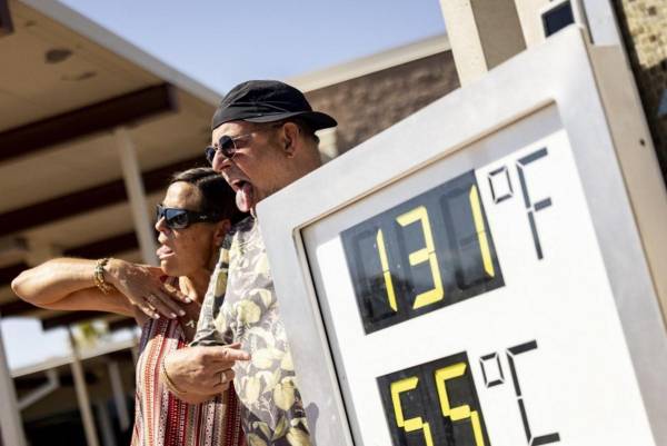 <i>Los visitantes posan junto a un termómetro que marca 131 grados Fahrenheit y 55 grados Celsius en el Centro de Visitantes del Parque Nacional del Valle de la Muerte, cerca de Furnace Creek, durante una ola de calor que afectó al sur de California el 7 de julio de 2024. FOTO ÉTIENNE LAURENT / AFP</i>