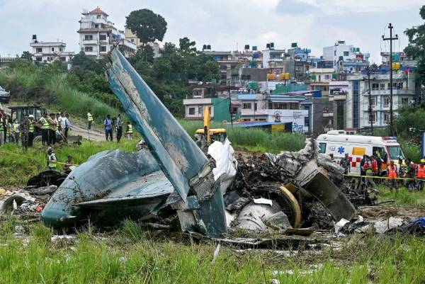 <i>El personal de seguridad inspecciona los restos de un vuelo de Saurya Airlines después de que se estrellara durante el despegue en el Aeropuerto Internacional Tribhuvan de Katmandú el 24 de julio de 2024. FOTO PRAKASH MATHEMA / AFP</i>