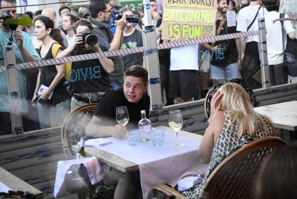 <i>Los manifestantes pusieron un cordón simbólico en la ventana de un bar-restaurante durante una protesta contra el turismo de masas en el callejón de Las Ramblas de Barcelona, ​​el 6 de julio de 2024. FOTO Josep LAGO /AFP</i>