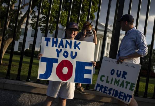 <i>Hugh, de 10 años, sostiene un cartel que dice Gracias Joe con su hermana Margot y su padre David Kieve a lo largo de Pennsylvania Avenue frente a la Casa Blanca en Washington, DC, el 21 de julio de 2024. FOTO SAMUEL CORUM / AFP</i>