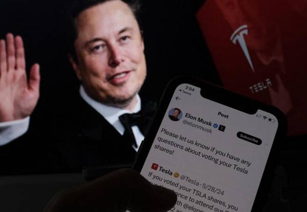 <i>Esta imagen ilustrativa creada el 12 de junio de 2024 en Los Ángeles muestra la campaña del empresario sudafricano Elon Musk lanzada en X antes de la reunión de accionistas de Tesla frente a su imagen en una pantalla. FOTO Chris DELMAS/AFP</i>