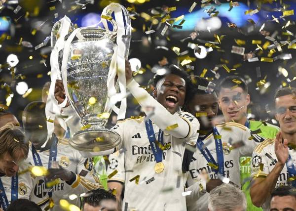 <i>El defensa francés #18 del Real Madrid, Aurelien Tchouameni, levanta el trofeo para celebrar la victoria al final de la final de la Liga de Campeones de la UEFA entre el Borussia Dortmund y el Real Madrid, en el estadio de Wembley, en Londres, el 1 de junio de 2024.INA FASSBENDER / AFP</i>