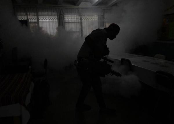 <i>Un trabajador rocía insecticidas contra el mosquito Aedes aegypti dentro de una escuela. FOTO JUAN ORDÓNEZ / AFP</i>