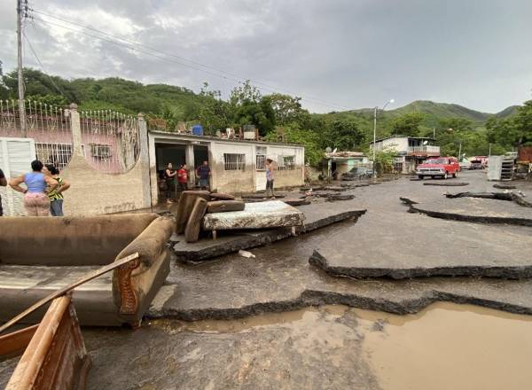<i>Los residentes intentan recuperar sus pertenencias de sus casas inundadas después de que un río se creciera debido a las fuertes lluvias tras el paso del huracán Beryl en la carretera de Cumaná a Cumanacoa, estado Sucre, Venezuela, el 2 de julio de 2024. FOTO VICTOR GONZALEZ / AFP</i>