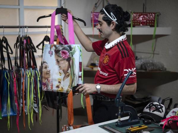 El diseñador de moda mexicano Mizael Perea, de 33 años, muestra uno de los diseños de bolsos hechos con materiales de carteles de campaña electoral en su taller en la Ciudad de México el 27 de junio de 2024.FOTO Yuri CORTEZ/AFP