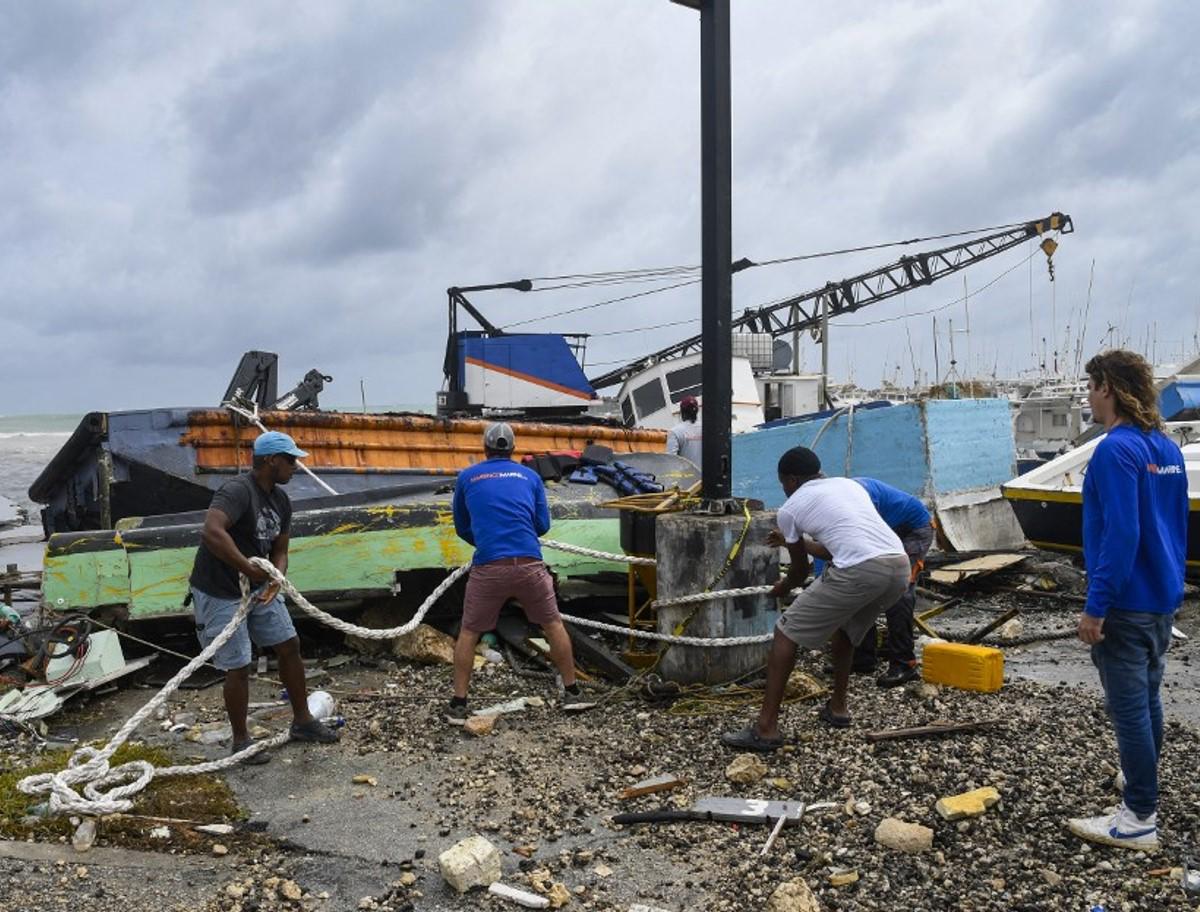 <i>Los pescadores intentan rescatar un barco pesquero dañado tras el paso del huracán Beryl en el mercado de pescado de Bridgetown, Bridgetown, Barbados, el 1 de julio de 2024. FOTO Randy Brooks/AFP</i>