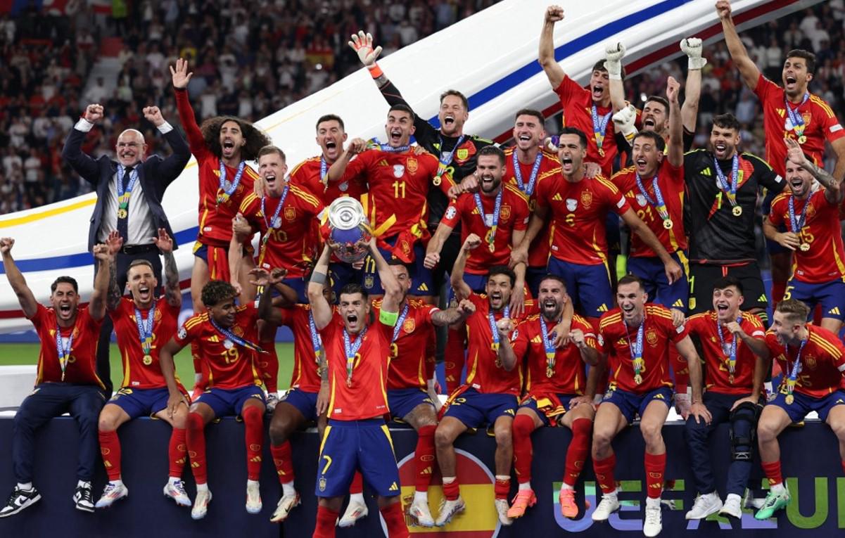 <i>El delantero español # 07 Álvaro Morata sostiene el trofeo y celebra con sus compañeros de equipo después de ganar el partido de fútbol final de la UEFA Euro 2024 entre España e Inglaterra en el Olympiastadion de Berlín el 14 de julio de 2024.FOTO Adrián DENNIS / AFP</i>