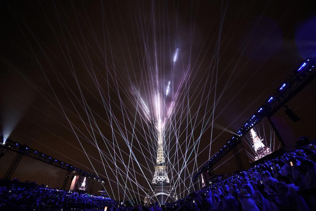 <i>PARÍS, FRANCIA - 26 DE JULIO: Un espectáculo de luces se lleva a cabo mientras los anillos olímpicos de la Torre Eiffel se iluminan durante la ceremonia de apertura de los Juegos Olímpicos de París 2024 en la Place du Trocadero el 26 de julio de 2024 en París, Francia. (Foto de Cameron Spencer / POOL / AFP)</i>